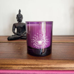 Purple third eye candle on wood