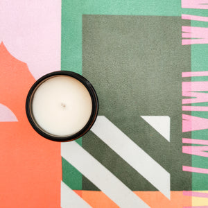 Candle viewed from above on colourful yoga mat